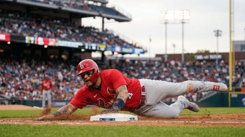 ベースに向かってスライディングする選手の画像