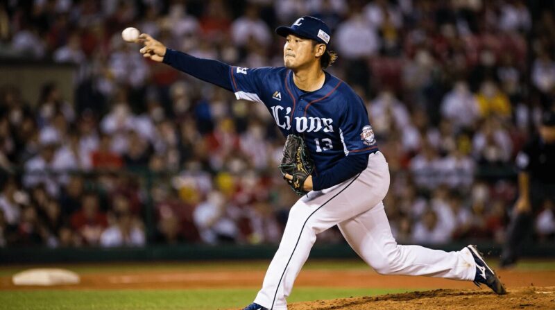 青いユニフォームを着た右投げのピッチャーの画像