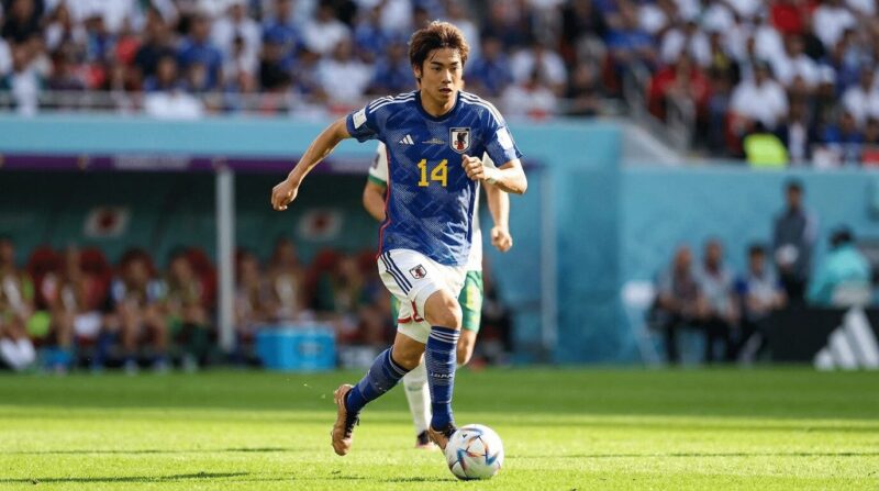 ピッチ上をドリブスしている日本代表選手の画像