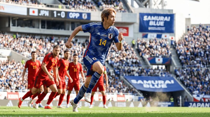 金髪の日本代表選手が走っている画像