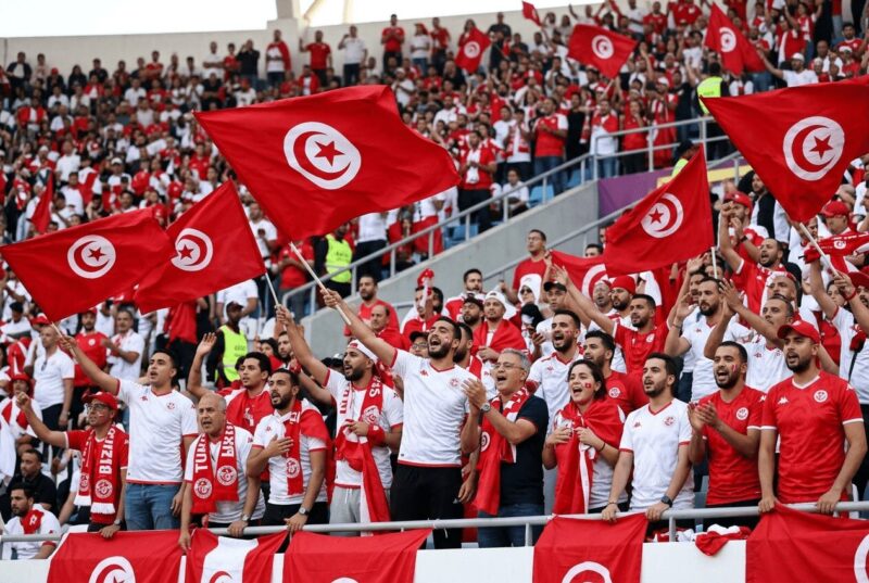 国旗を掲げて応援するチュニジアサポーターの画像