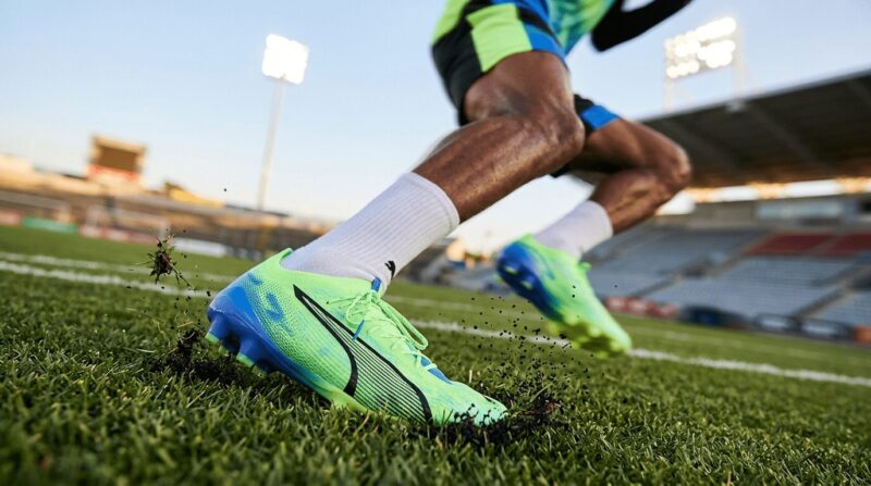 緑色のPUMA ULTRA5を履いている黒人男性の足の画像