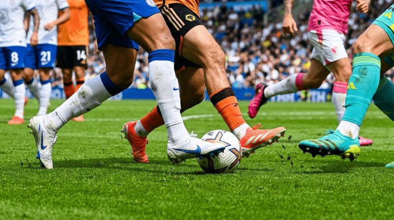 サッカーの試合中にボールを取り合っている足元の画像