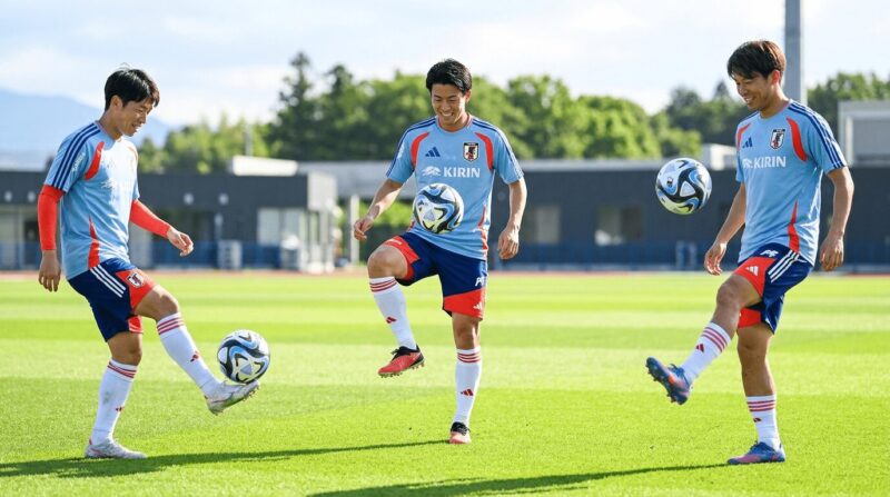 代表選手風の選手たちがボールを使ったアップ運動をしている