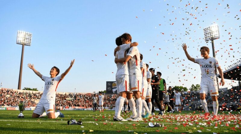 ピッチ上で勝利を喜ぶサッカーチームの瞬間