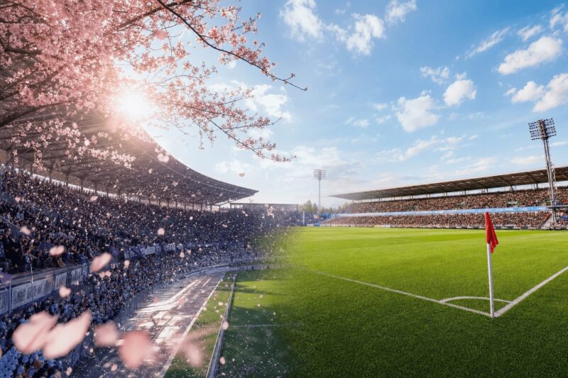 桜が舞う日本のスタジアム（左）から青い空の欧州中堅リーグスタジアム（右）への滑らかな移行。