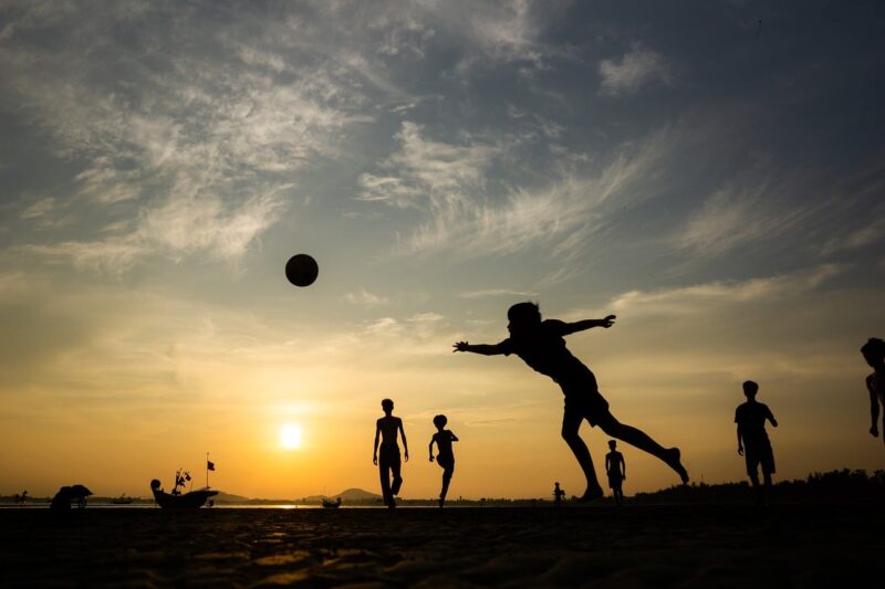 夕暮れまでサッカーをしている子供達のシルエット画像