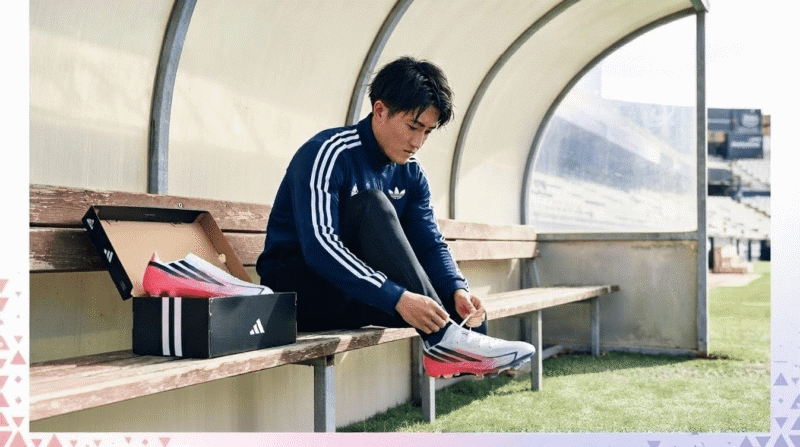 若い日本人選手がベンチで最新モデルのアディダスF50を履いている姿